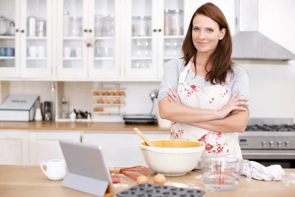 Hän luottaa leipomistaitoihinsa. Muotokuva itsevarma nainen leipoo keittiössä. — kuvapankkivalokuva