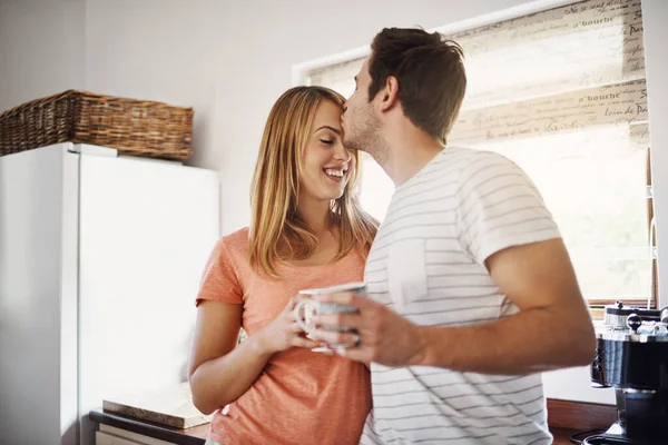 Matinées faites avec amour. Tourné d'un jeune couple affectueux dégustant un café ensemble le matin à la maison. — Photo