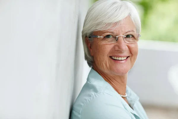 Вдихайте впевненість, вдихайте сумніви. Портрет старшої жінки, яка посміхається в камеру . — стокове фото