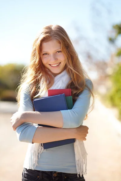 Le encantan sus libros. Retrato de una joven sosteniendo sus libros escolares cerca de su pecho. —  Fotos de Stock