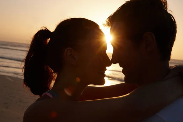 日没時の真の愛。夕暮れ時にビーチでロマンチックなカップルのシルエット. — ストック写真