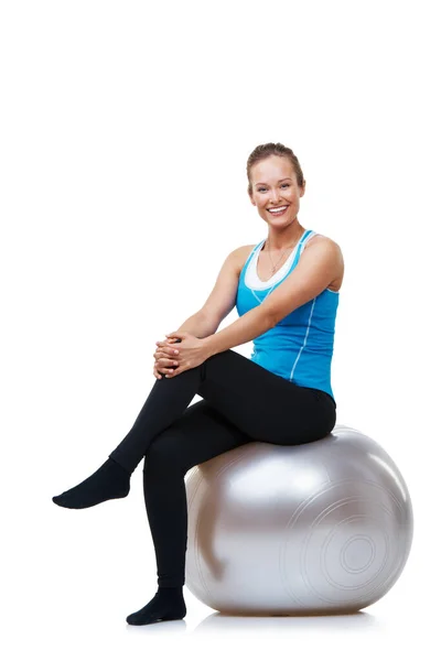 Siempre me siento genial después de un entrenamiento pesado. Retrato de una mujer sonriente sentada en su pelota de ejercicio. — Foto de Stock