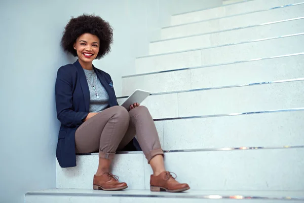 Мбаппе поставил перед собой цель добиться успеха. Портрет молодой предпринимательницы с цифровой табличкой на лестнице в современном офисе. — стоковое фото