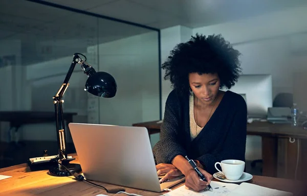 Avanzando para anular sus plazos. Recorte de una joven empresaria que trabaja hasta tarde en un ordenador portátil en una oficina. —  Fotos de Stock