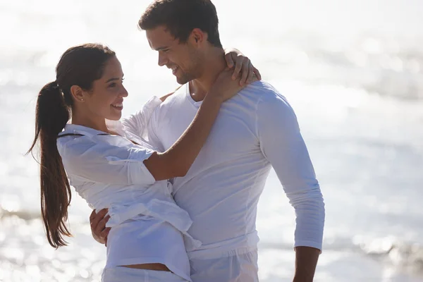 Guardarsi negli occhi. Ritagliato foto di una giovane coppia che abbraccia in spiaggia. — Foto Stock