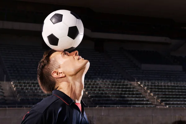 Dovednost a rovnováha. Zastřelen mladým fotbalistou balancujícím míč na hlavě. — Stock fotografie