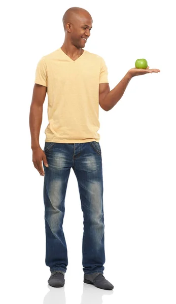 A fazer a escolha saudável. Estúdio tiro de um homem afro-americano atraente segurando uma maçã e olhando para ele. — Fotografia de Stock