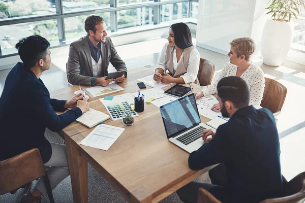 Planeando formas de tener éxito a su alcance. Fotografía de un grupo diverso de empresarios que se reúnen en una oficina. —  Fotos de Stock