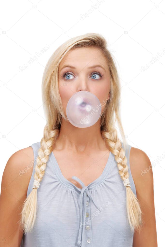 Practising her bubble blowing. A young blonde woman blowing a bubblegum bubble.
