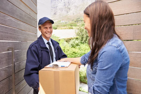 I always use a trustworthy courier. Shot of a friendly delivery man delivering a package to a young woman. — Stock Photo, Image