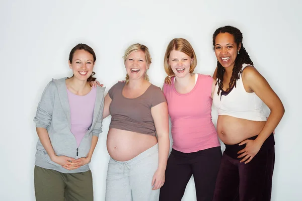 La grossesse est une joie pour eux. Des amies enceintes debout ensemble alors qu'elles étaient isolées sur du blanc. — Photo