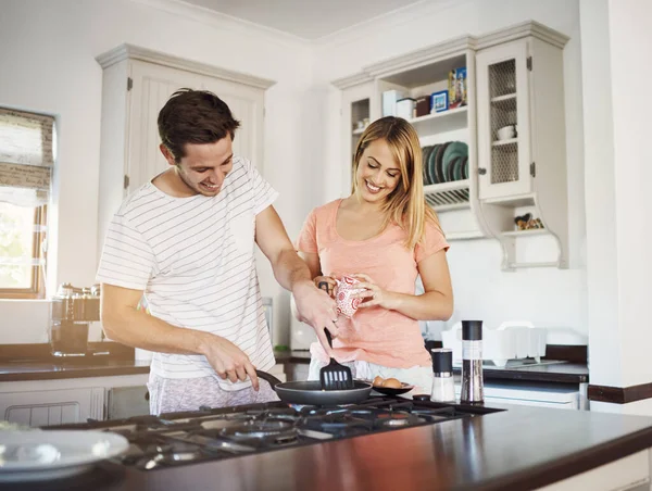 Fazer do pequeno-almoço uma experiência de ligação. Tiro de um jovem casal feliz cozinhar café da manhã juntos em casa. — Fotografia de Stock