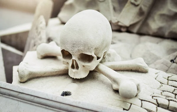 Assustador, mas fixe. Fecho de uma estátua de caveira em uma sepultura em um cemitério do lado de fora durante o dia. — Fotografia de Stock