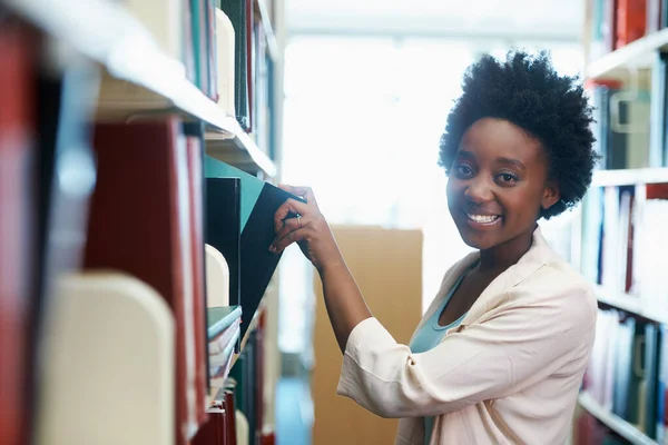 Sto studiando per l'esame finale. Una giovane donna che seleziona alcuni libri in biblioteca. — Foto Stock