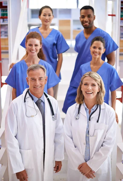 Dají vám tu nejlepší možnou péči. Portrét rozmanitého týmu lékařů stojících na schodišti v nemocnici. — Stock fotografie
