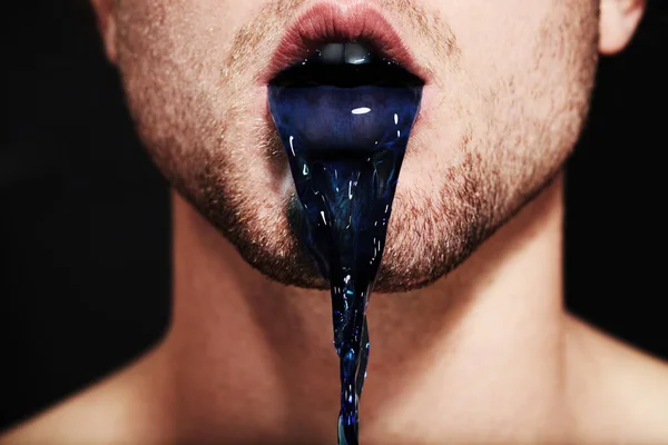 Цвет вранья. Крупный план молодого человека рот выплевывает фиолетовую жидкость. — стоковое фото