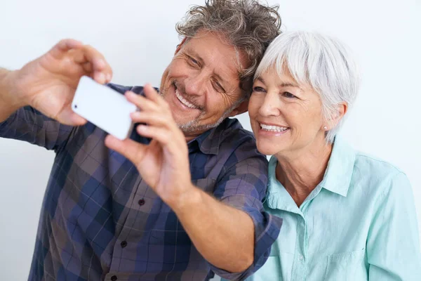 Det är en bra en. Skjuten av ett lyckligt par som tittade på en mobiltelefon. — Stockfoto