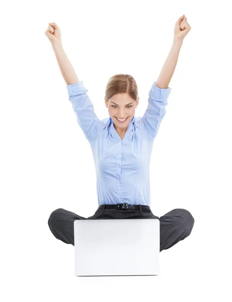 Mejor que nunca. Estudio de una joven mujer de negocios usando su portátil en el suelo y animando con éxito contra un fondo blanco. — Foto de Stock