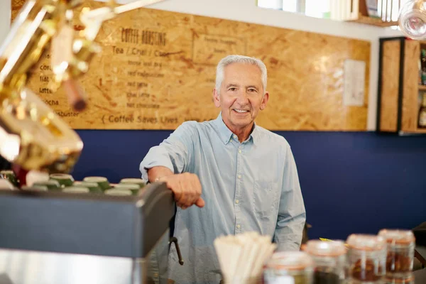 Ser dono de um café sempre foi o meu sonho. Tiro de um homem sênior trabalhando em um café. — Fotografia de Stock