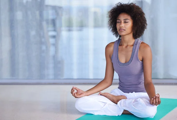 Nalezení vnitřního míru. Výstřel atraktivní mladé ženy meditující na podložce na cvičení. — Stock fotografie