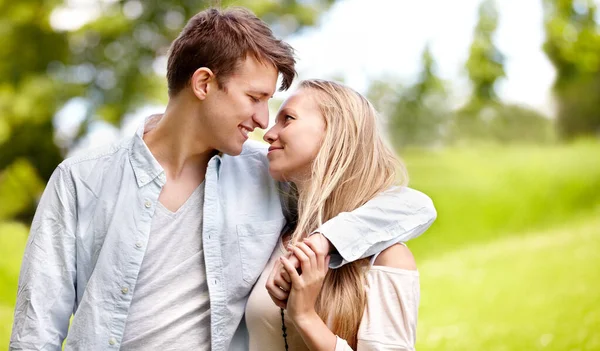 Ils n'ont d'yeux que pour l'autre. Jeune couple debout ensemble dans le parc. — Photo