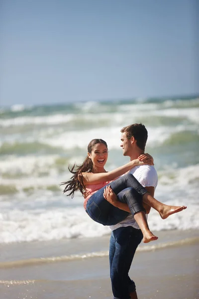 Kannan maailmaa käsissäni. Laukaus onnellinen nuori pari on leikkisä rannalla. — kuvapankkivalokuva