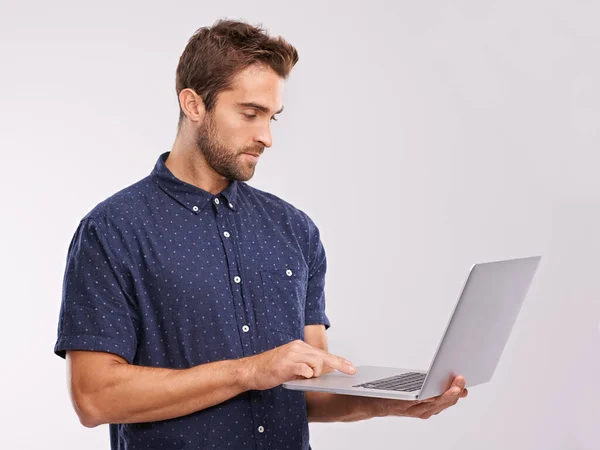 Liberdade online. Uma foto de estúdio de um homem bonito usando um laptop. — Fotografia de Stock