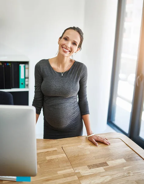 Végre készen állok a szülési szabadságra. Vágott portré egy terhes üzletasszonyról, aki az íróasztalánál áll az irodában.. — Stock Fotó