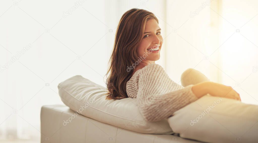 Today is going to be a great day. Shot of a young woman relaxing on her sofa at home.