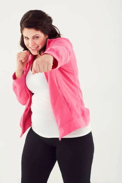 Una libra a la vez. Captura de estudio de una mujer joven lanzando golpes mientras usa ropa de ejercicio. — Foto de Stock