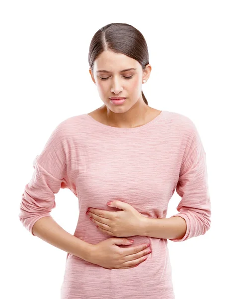Los calambres en el estómago son los peores. Captura de estudio de una atractiva joven que sufre de calambres estomacales. — Foto de Stock