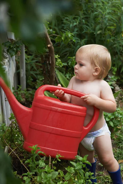 Curioso sobre cómo funciona la naturaleza. Un adorable niño regando el jardín. —  Fotos de Stock