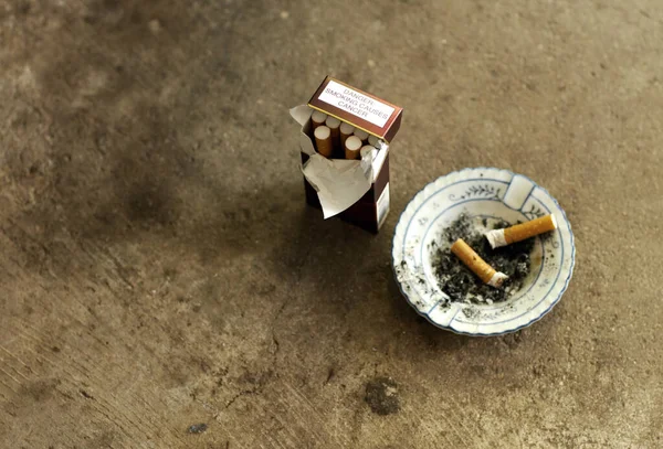 Rompe el hábito. Toma de un cenicero, colillas de cigarrillos y un paquete de cigarrillos. — Foto de Stock