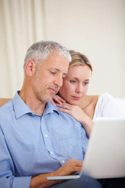 Charlando en línea. Una pareja casada sentada con su portátil en casa. —  Fotos de Stock