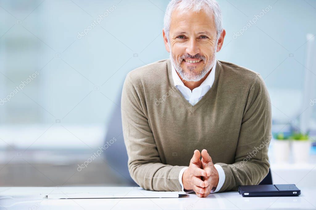 Lets get down to business. Portrait of a mature businessman sitting at his office desk.