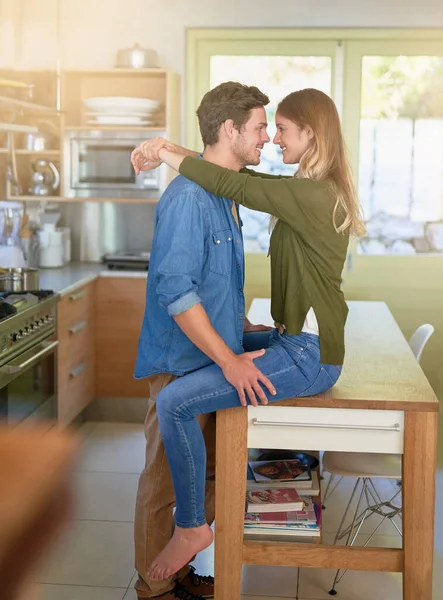 Me estoy poniendo romántico en la cocina. Foto de una joven pareja cariñosa abrazándose en su cocina. —  Fotos de Stock