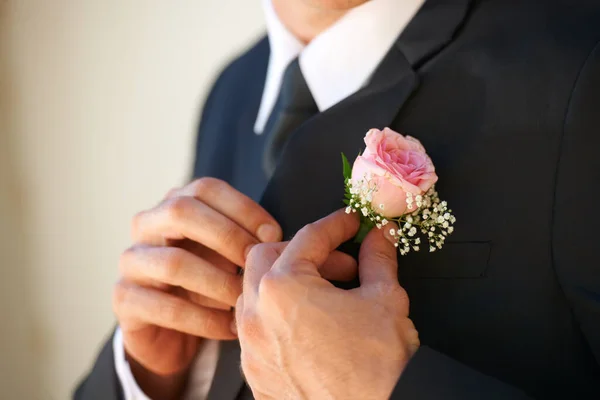 Mi assicuro che sia perfetto per la futura moglie. Immagine ritagliata di uno sposo che si adatta al boutonniere prima della cerimonia nuziale. — Foto Stock