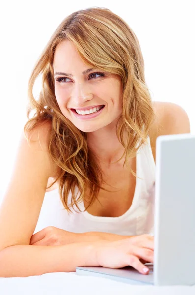 Relaxar e fazer um pouco de navegação na web.... Uma jovem mulher usando seu laptop enquanto no chão em casa. — Fotografia de Stock