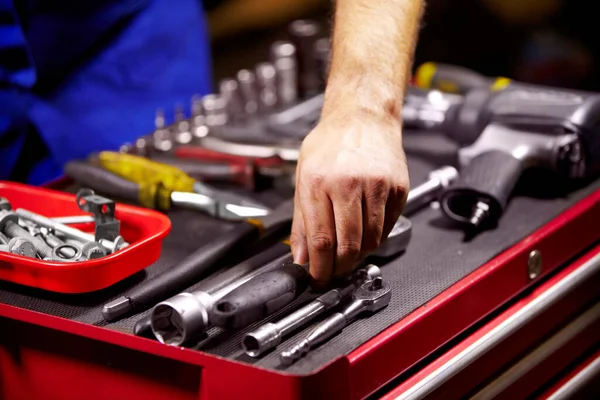 Encontrar la herramienta perfecta. Imagen recortada de las manos de un hombre agarrando una herramienta de su caja de herramientas. — Foto de Stock