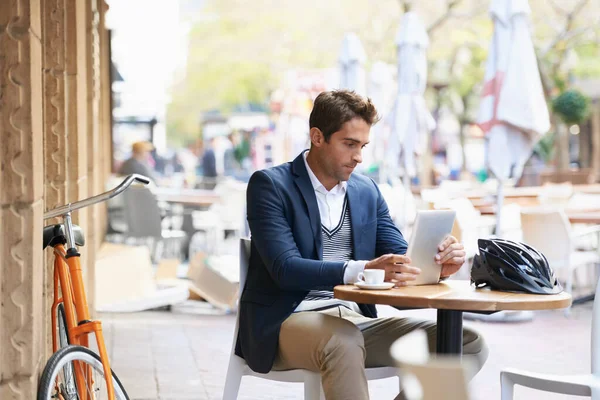 Seine erste Station am Morgen.... Aufnahme eines jungen Geschäftsmannes, der mit einem digitalen Tablet in einem Café im Freien sitzt. — Stockfoto