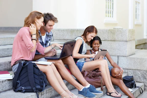 Grupo de estudio moderno. Adolescentes jóvenes en sus pasos universitarios compartiendo notas e información en sus computadoras portátiles. —  Fotos de Stock