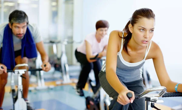 Donna che si allena in bici da corsa in palestra. Bella donna che lavora su una bici stazionaria in palestra. — Foto Stock