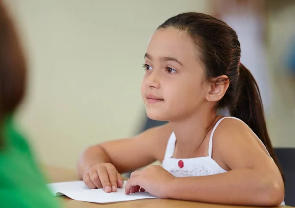 Who ever likes a test. An eager school girl sitting at her desk. — Stock Photo, Image