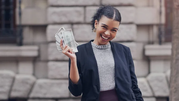 Jsem nabitá. Oříznutý portrét atraktivní mladé podnikatelky usmívající se při držení stohu peněz, zatímco stojí venku ve městě. — Stock fotografie