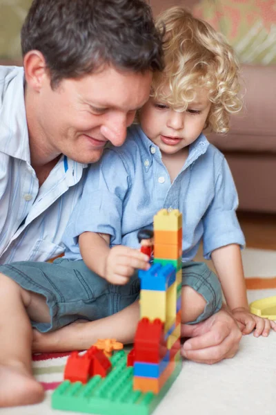 É um construtor brilhante, tal como o pai. Um pai observando seu filho criança brincando com blocos de construção. — Fotografia de Stock
