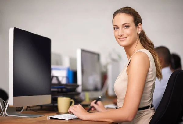 Genieten van haar werkomgeving. Portret van een aantrekkelijke jonge kantoormedewerker achter haar computer. — Stockfoto
