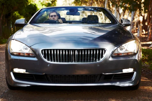 Хес серйозно ставиться до водіння. Портрет чоловіка, що сидить на своєму срібному спортивному автомобілі, який стоїть перед вами . — стокове фото