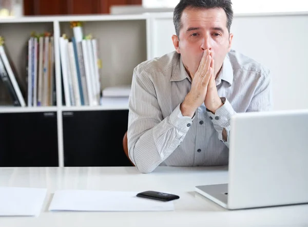 Exaustão no local de trabalho. Retrato de um empresário estressado sentado na frente de seu laptop. — Fotografia de Stock