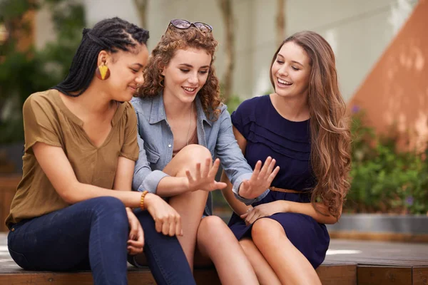 Tjejer, kolla in den här manikyren. En grupp unga kvinnor som sitter utomhus och beundrar en väns naglar. — Stockfoto