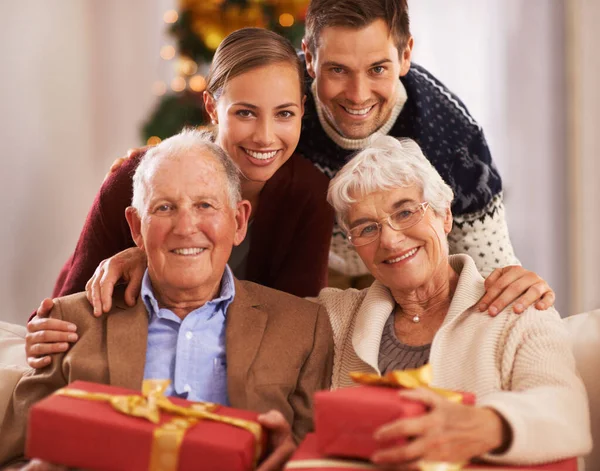 Rozpieszczają rodziców w Boże Narodzenie. Portret szczęśliwej rodziny z prezentami na Boże Narodzenie. — Zdjęcie stockowe